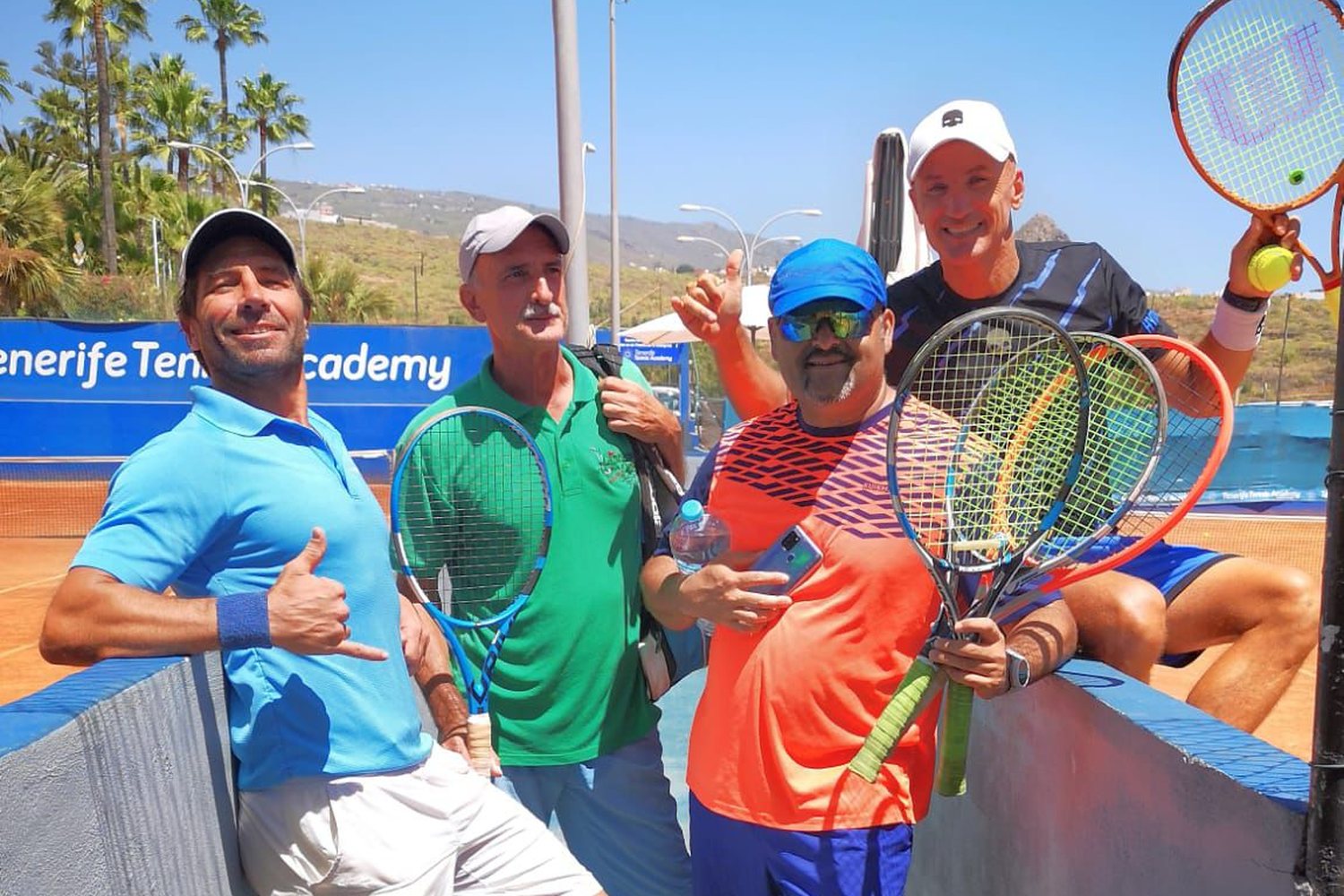 Adult players with their rackets at the net on the courts at Chayofa