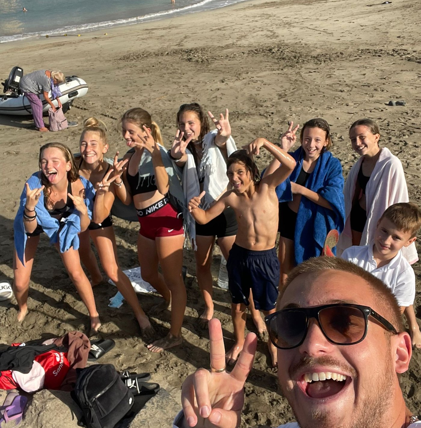 Players and a coach on the beach after an evening swim