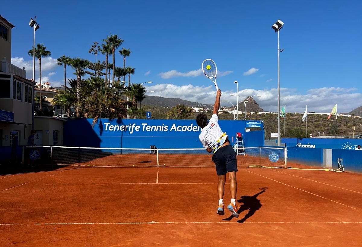 A player serving on the red clay at Chayofa