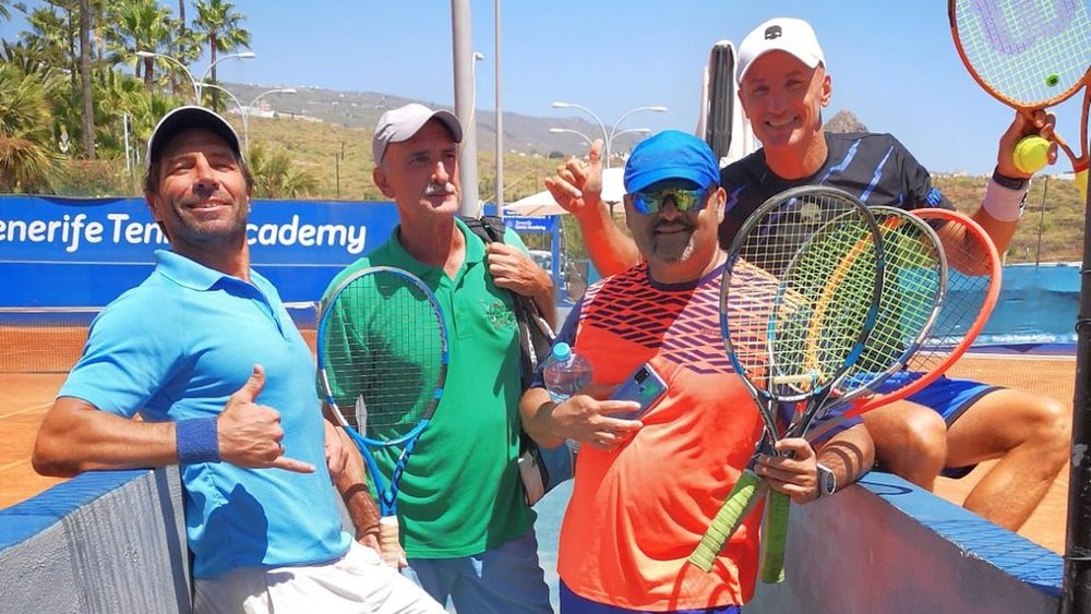 Adult players with their rackets at the net on the clay at Chayofa