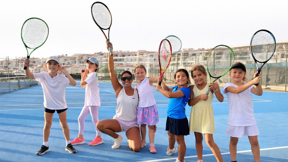 Young players holding their rackets up on the hard courts at T3