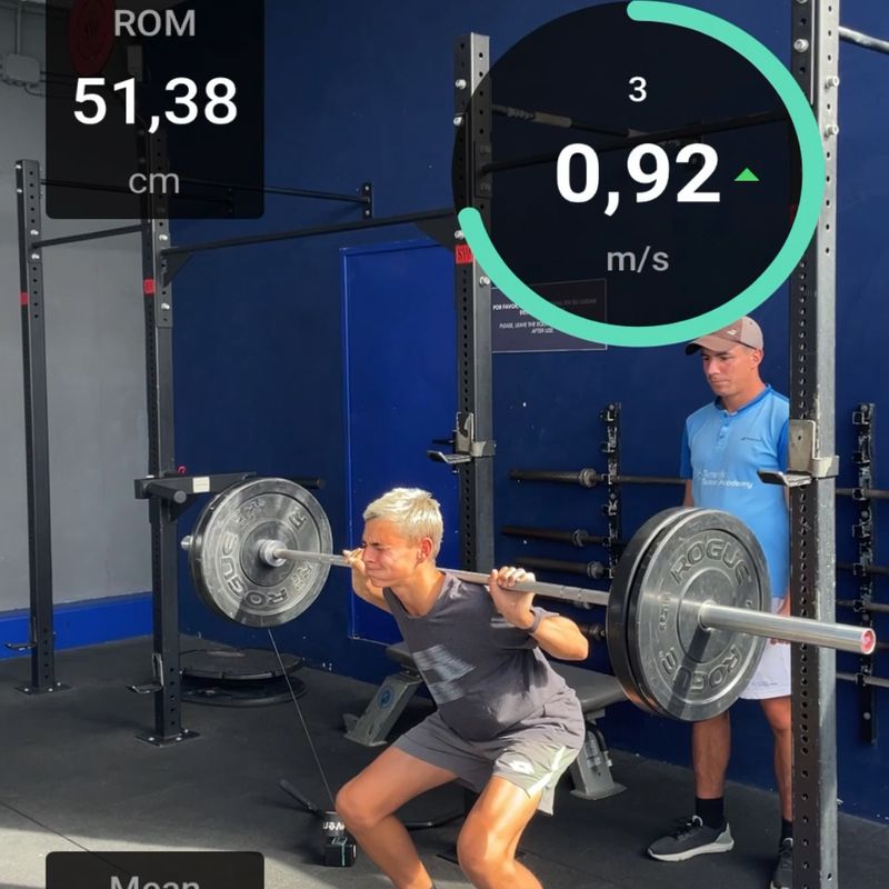 A player working under a loaded bar in the gym