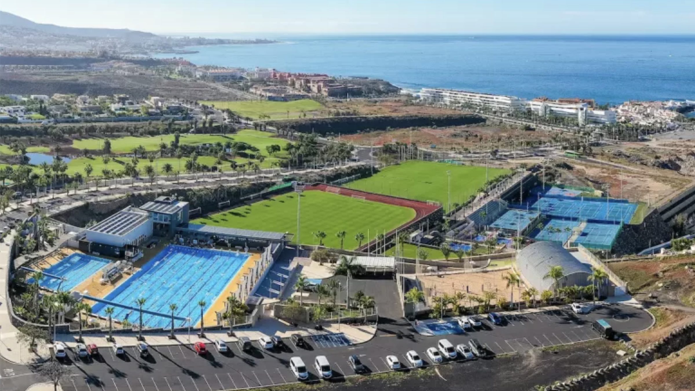 The T3 campus at La Caleta from the air, with the fifty metre pool, the athletics track and the tennis courts, and the Atlantic behind