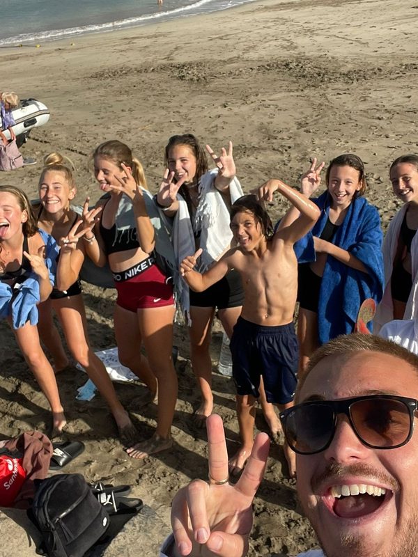 Players and a coach on the beach after an evening swim